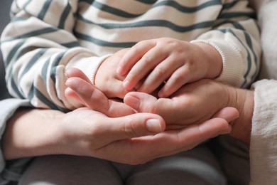 Photo of Family holding their hands together, closeup view