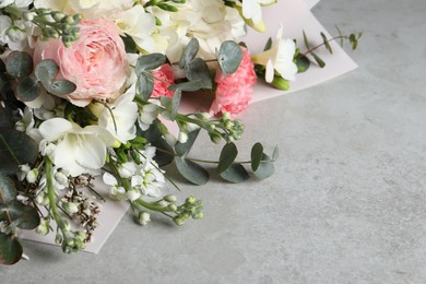 Photo of Bouquet of beautiful flowers on light grey table, closeup. Space for text
