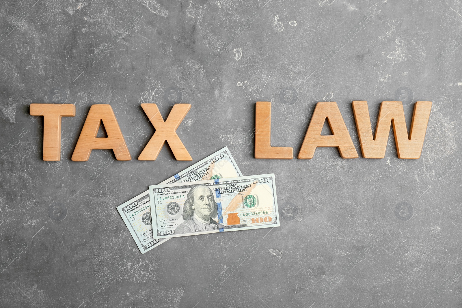 Photo of Flat lay composition with words TAX LAW and money on grey background