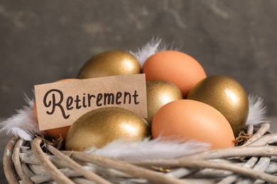 Photo of Different eggs and card with word Retirement in nest, closeup. Pension concept
