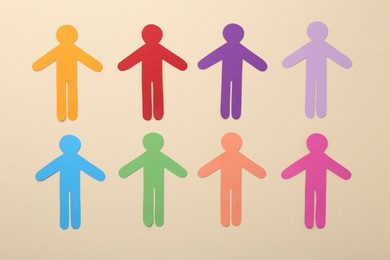 Equality concept. Different human figures on beige background, flat lay