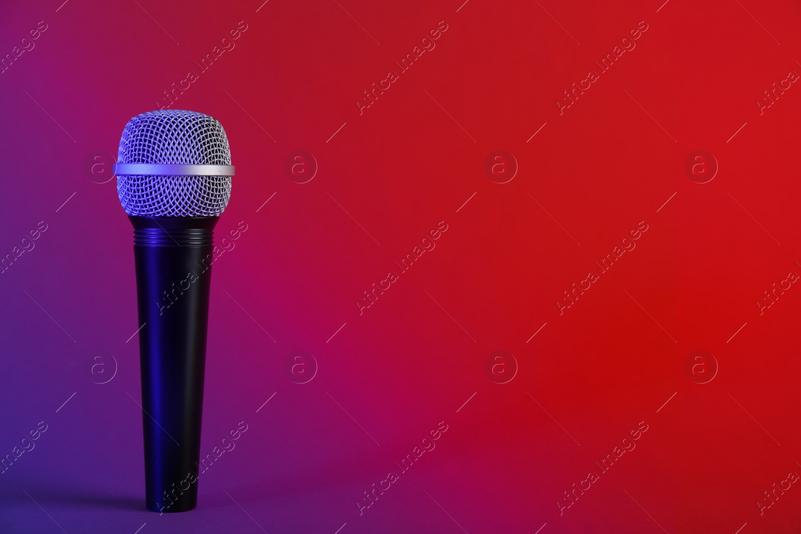 Photo of Modern microphone on color background. Space for text