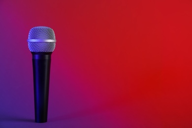 Photo of Modern microphone on color background. Space for text