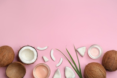 Photo of Flat lay composition with ripe coconuts, natural organic oil and space for text on pink background