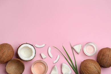 Flat lay composition with ripe coconuts, natural organic oil and space for text on pink background