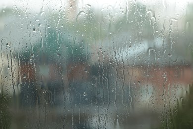 Photo of Window glass with droplets on rainy day, closeup