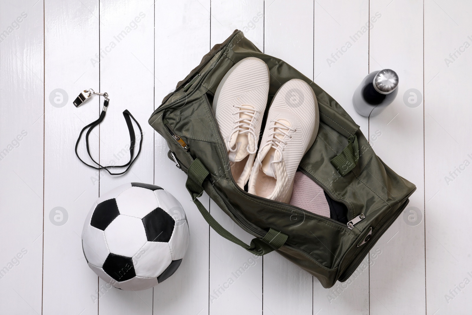 Photo of Gym bag and sports equipment on white wooden background, flat lay