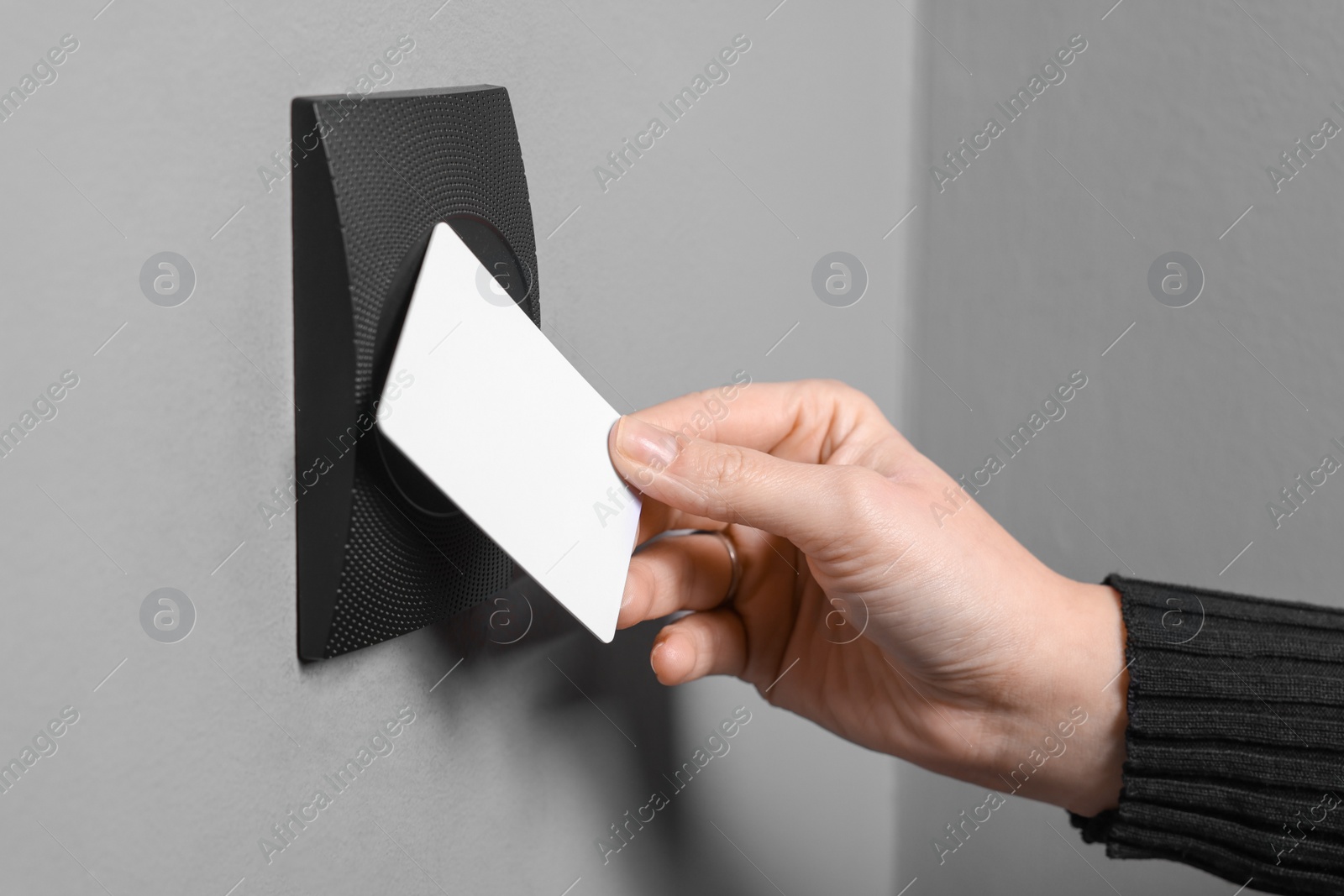 Photo of Woman opening magnetic door lock with key card, closeup. Home security