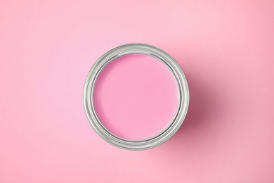 Photo of Open can of paint on pink background, top view