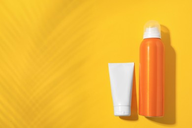 Photo of Sunscreens on yellow background, flat lay and space for text. Sun protection care