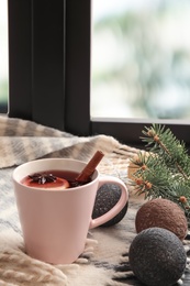 Photo of Composition with cup of hot winter drink and plaid near window. Cozy season