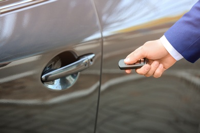 Closeup view of man opening car door with remote key