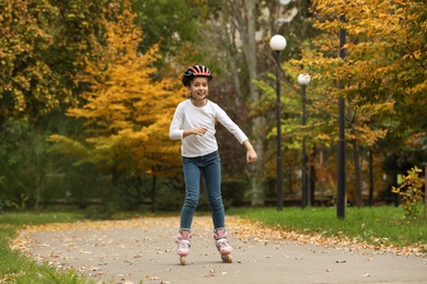 Photo of Cute girl roller skating in autumn park