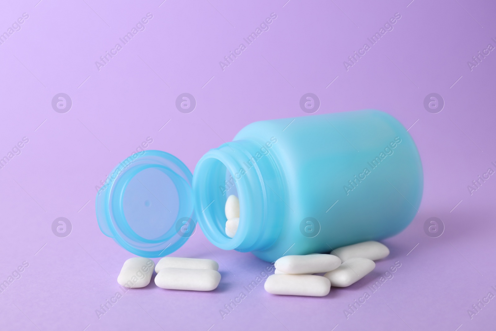 Photo of Jar with chewing gums on lilac background