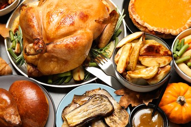 Photo of Traditional Thanksgiving day feast with delicious cooked turkey and other seasonal dishes served on grey table, flat lay