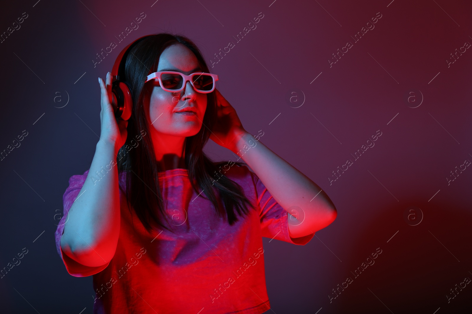 Photo of Stylish woman with headphones wearing sunglasses on color background, space for text