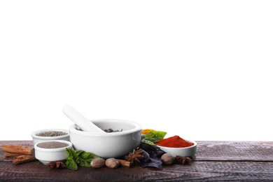 Photo of Mortar and different spices on wooden table against white background. Space for text