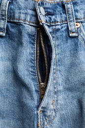 Photo of Blue jeans with unbuttoned fly as background, top view. Exhibitionist concept