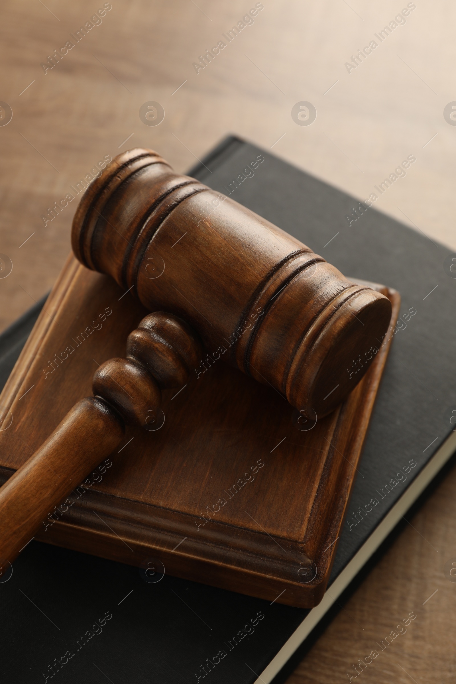 Photo of Law concept. Gavel and book on wooden table, closeup