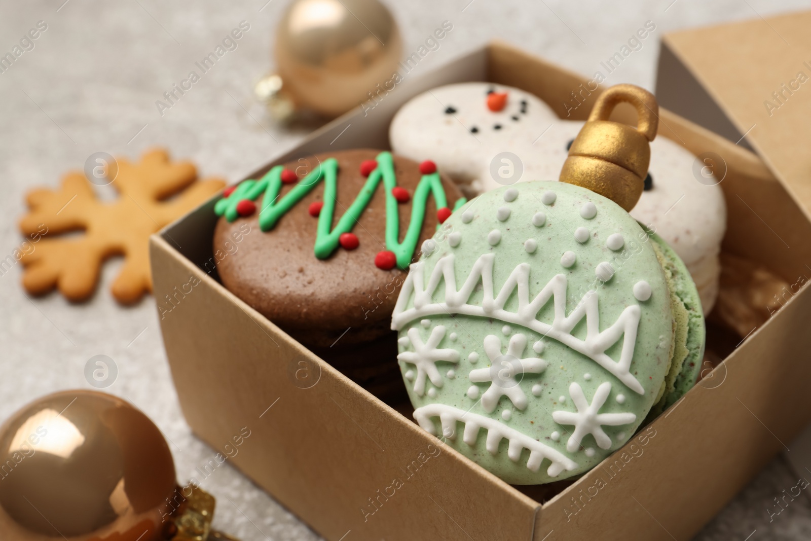 Photo of Beautifully decorated Christmas macarons in box on table, closeup