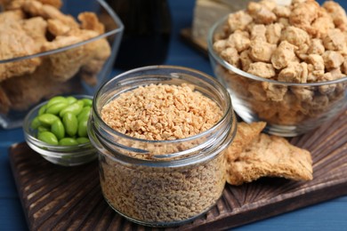 Photo of Dehydrated soy meat and other organic products on blue table, closeup