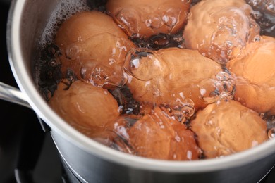 Chicken eggs boiling in pot, closeup view