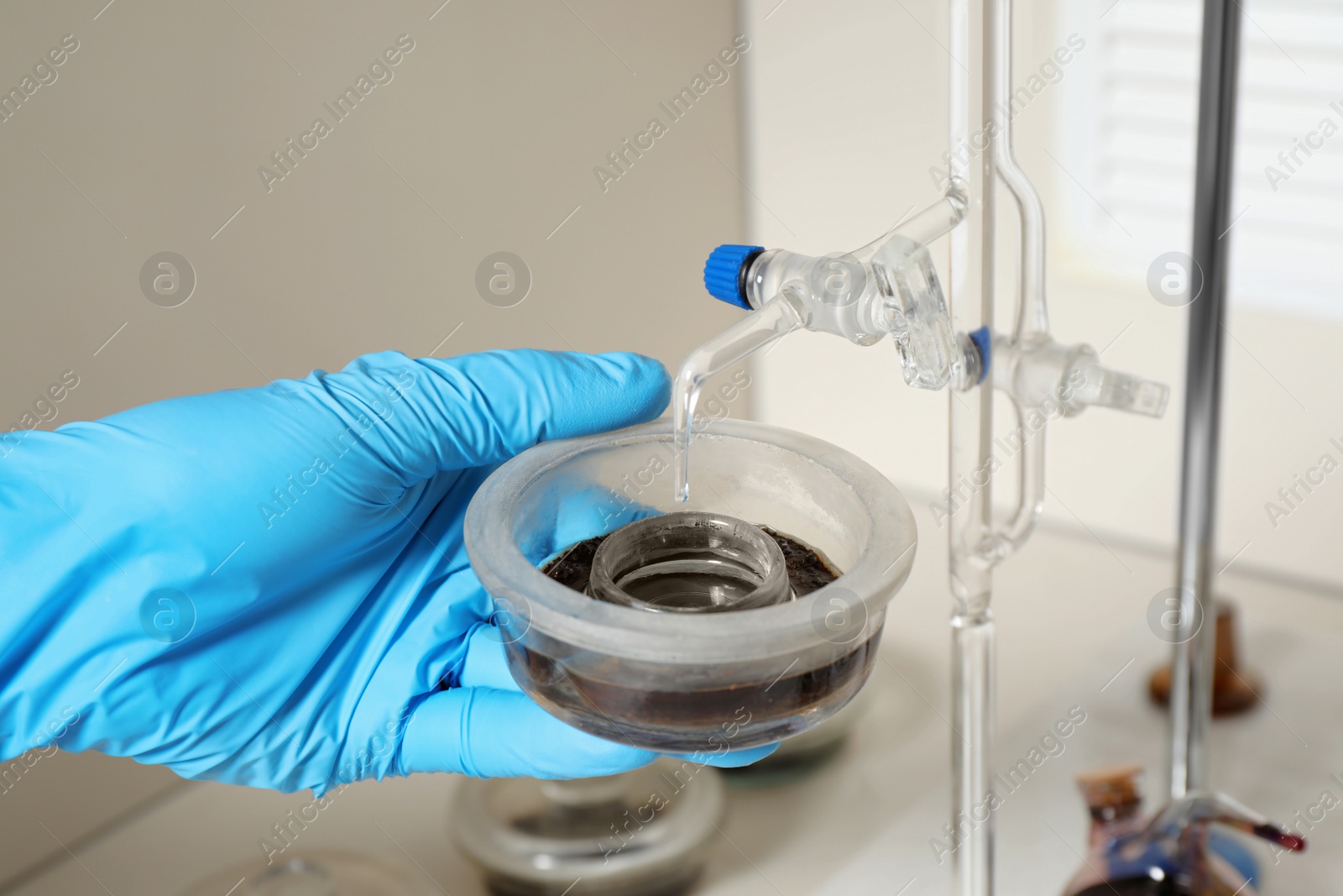 Photo of Scientist doing nitrogen determination of soil sample at table, closeup. Laboratory research