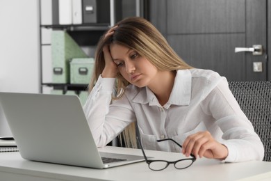 Photo of Sleepy young woman at workplace in office