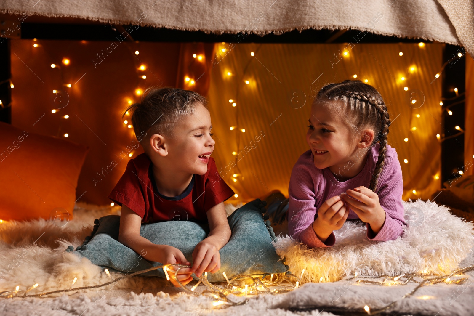 Photo of Happy kids in decorated play tent at home