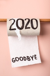 Photo of Toilet paper roll with text Goodbye 2020 on pink background