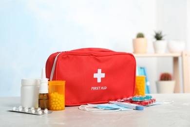 Photo of First aid kit with pills on table indoors