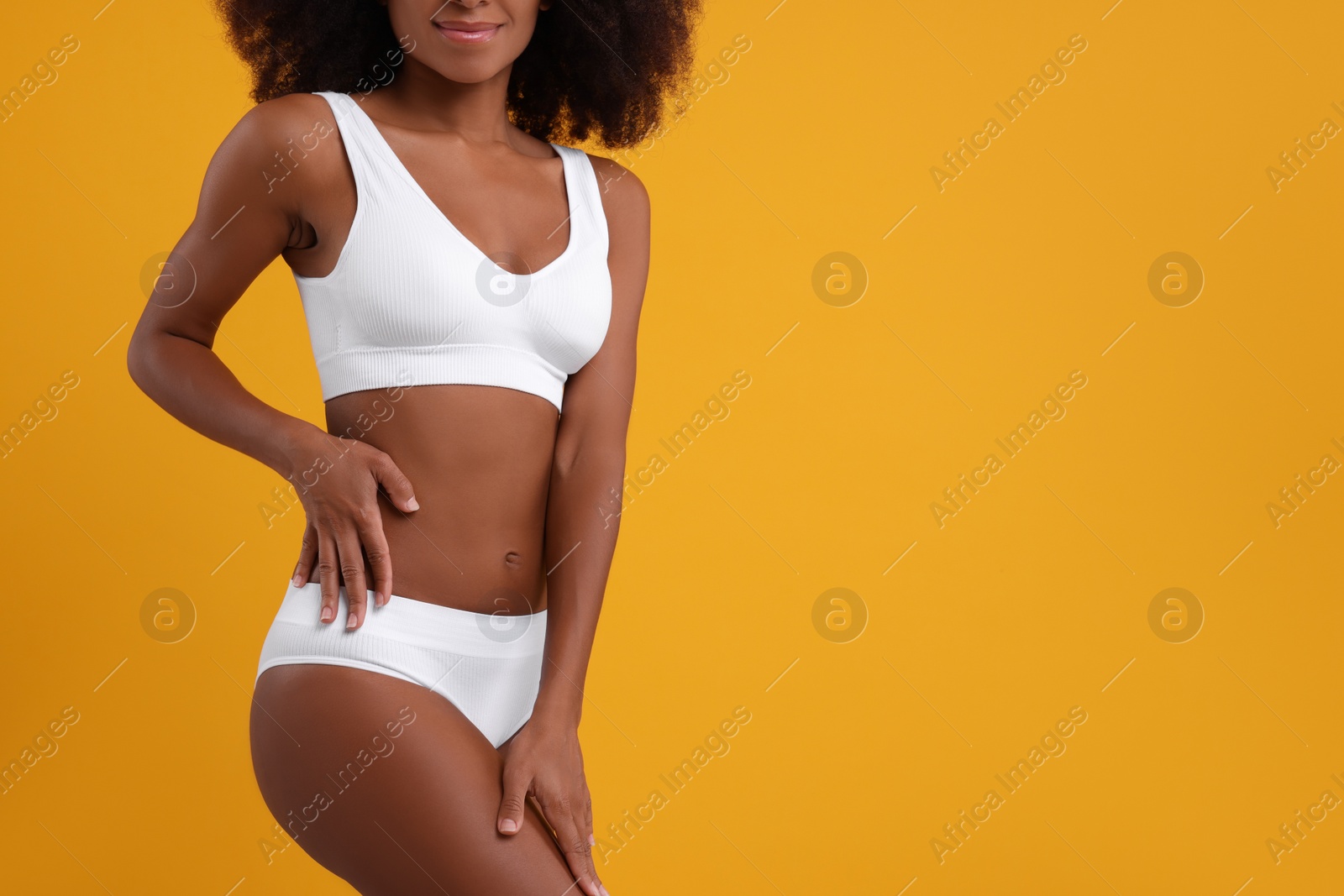 Photo of Woman in stylish bikini on yellow background, closeup. Space for text