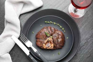 Photo of Tasty grilled beef meat served on black table, flat lay