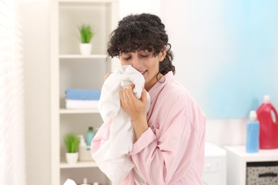 Beautiful woman with clean laundry at home