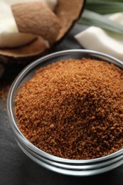 Photo of Natural coconut sugar in glass bowl on black table