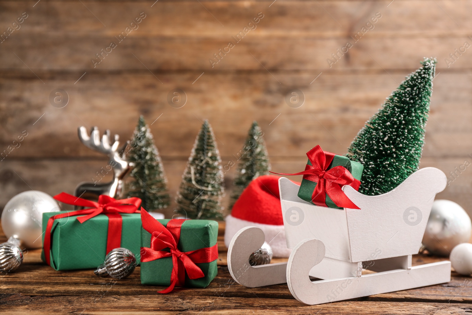 Photo of Beautiful Christmas composition with miniature sleigh on wooden table