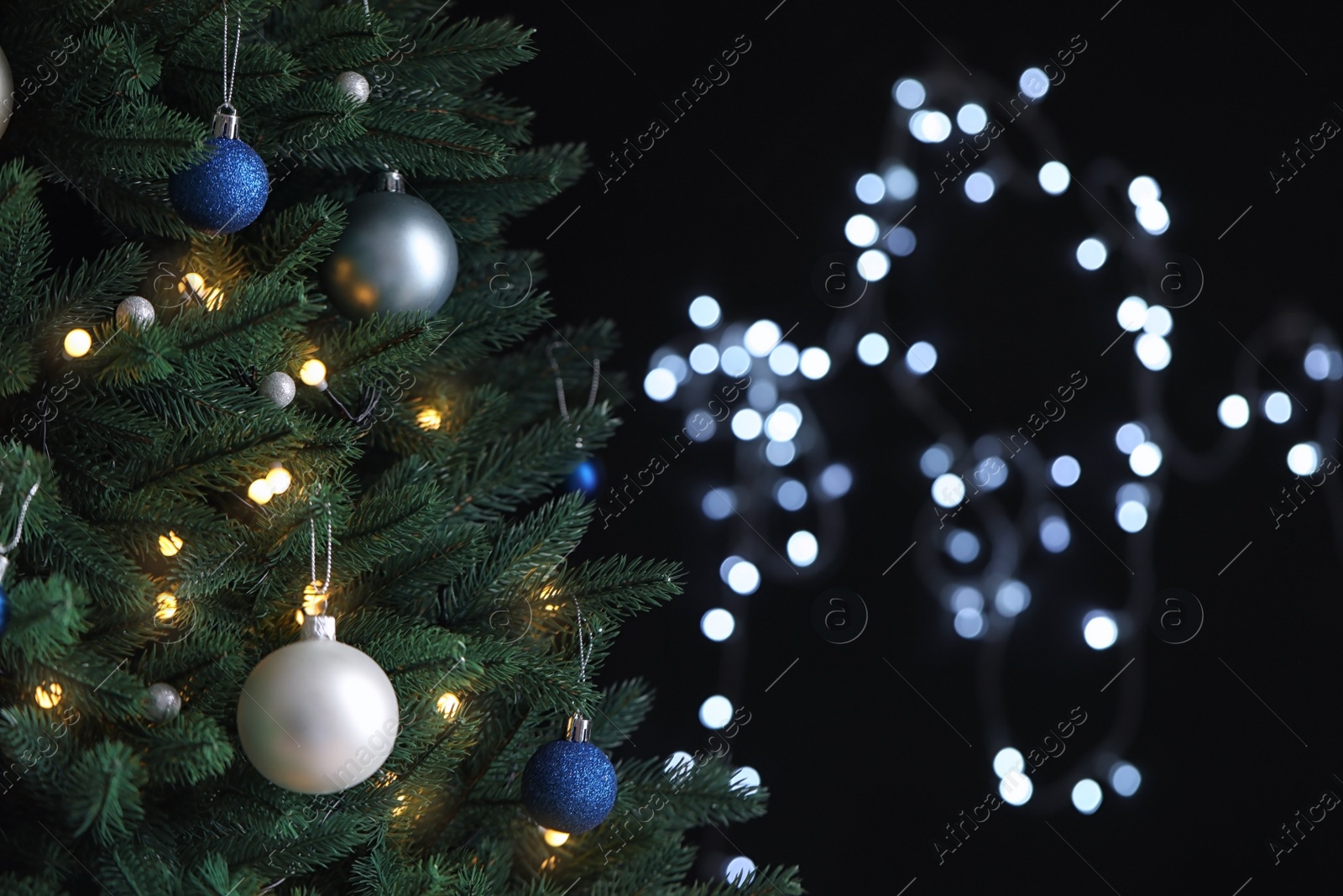 Photo of Beautiful Christmas tree with decor against blurred lights on background. Space for text