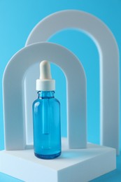 Photo of Stylish presentation of serum on light blue background