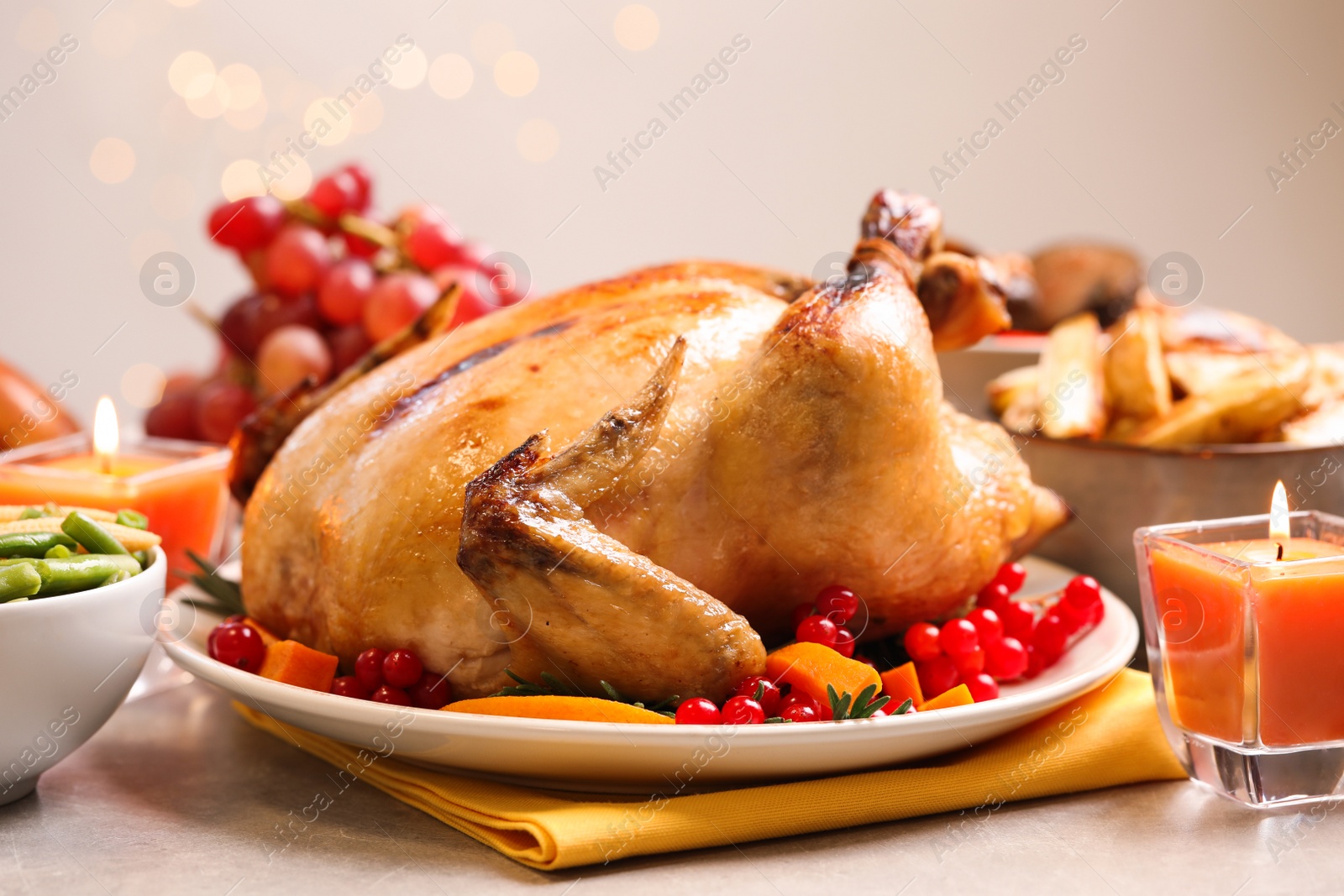 Photo of Traditional Thanksgiving day feast with delicious cooked turkey and other seasonal dishes served on light table, closeup