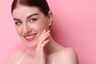 Photo of Portrait of smiling woman on pink background, closeup
