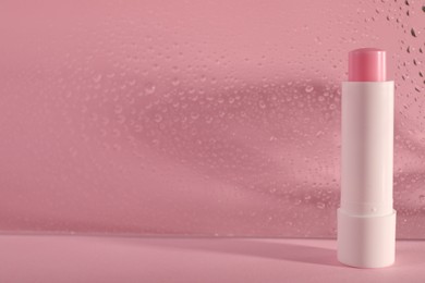 Photo of One lip balm on pink background, space for text