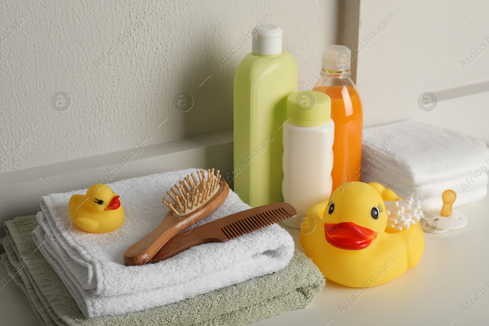 Photo of Bathroom towels, toy and baby accessories on white table