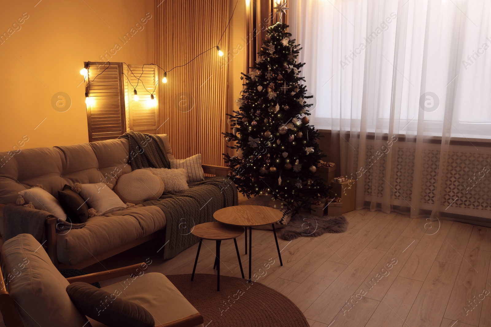 Photo of Comfortable furniture and Christmas tree in stylish room