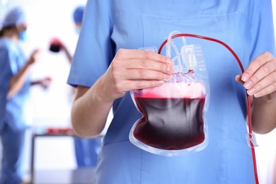 Doctor holding blood pack for transfusion at hospital, closeup. Donation day