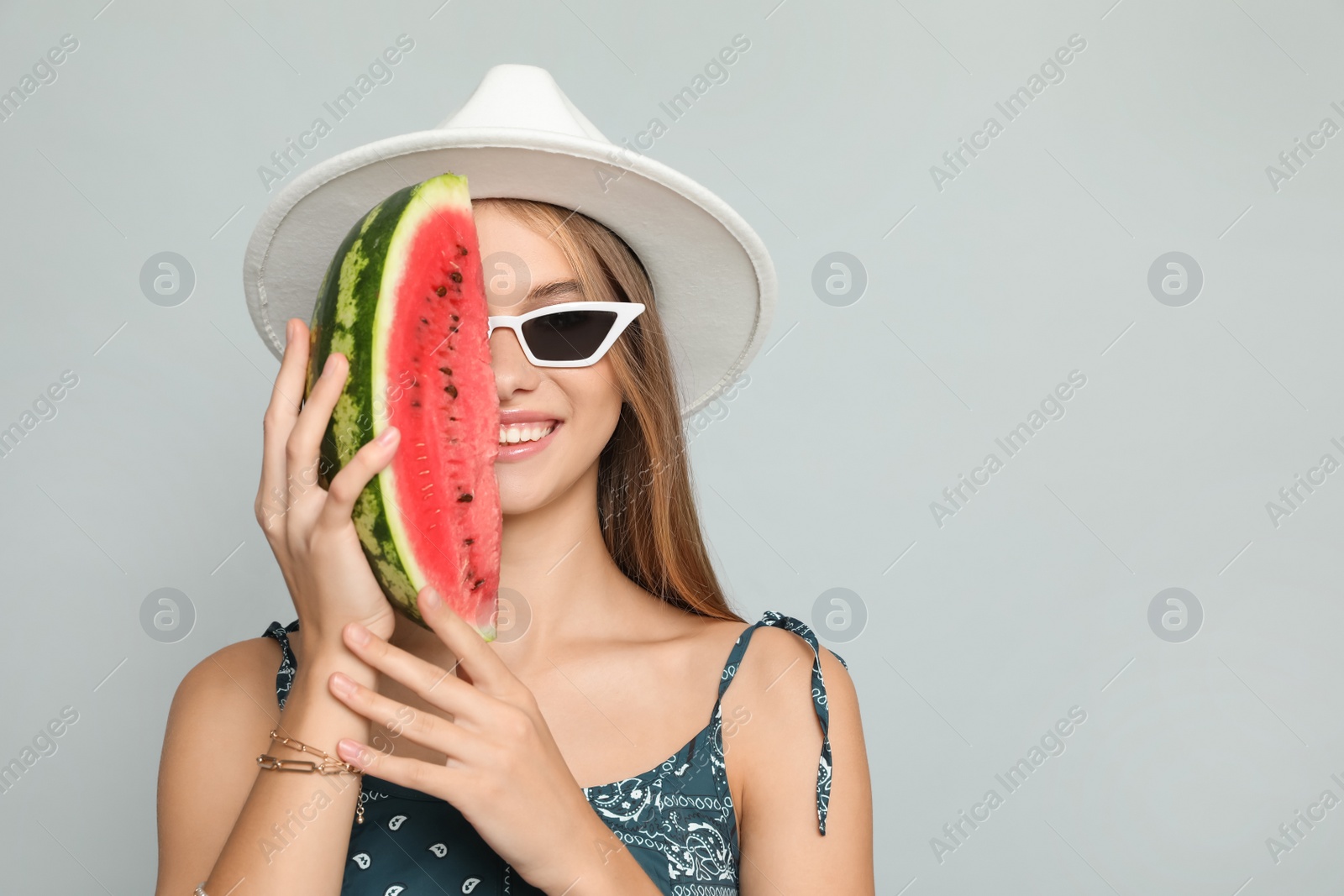 Photo of Beautiful girl with watermelon on grey background. Space for text