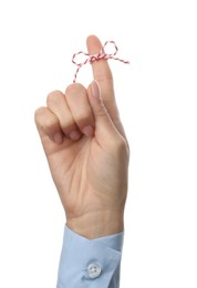 Woman showing index finger with tied bow as reminder on white background, closeup