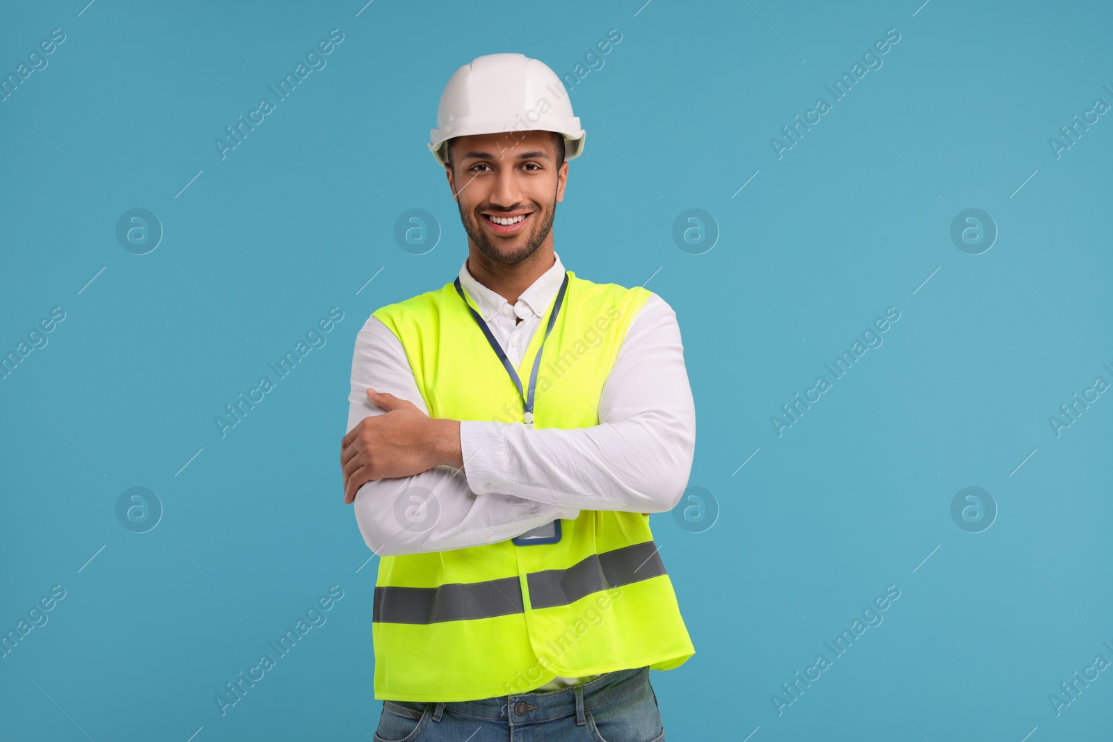 Photo of Engineer in hard hat on light blue background