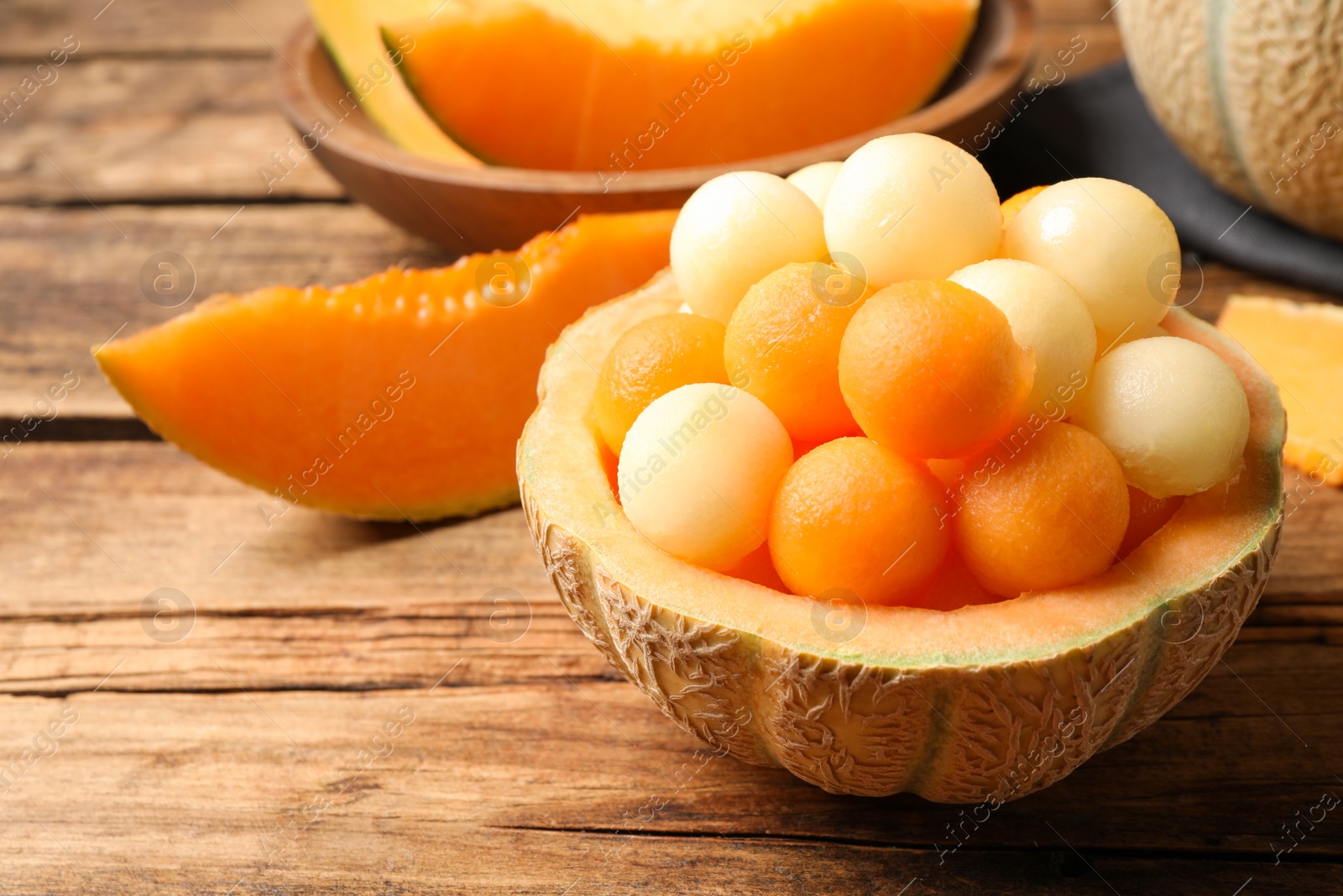 Photo of Many different melon balls on wooden table