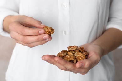 Photo of Woman holding tasty walnuts, closeup. Organic snack