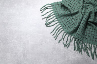 Soft green scarf on light grey background, top view. Space for text